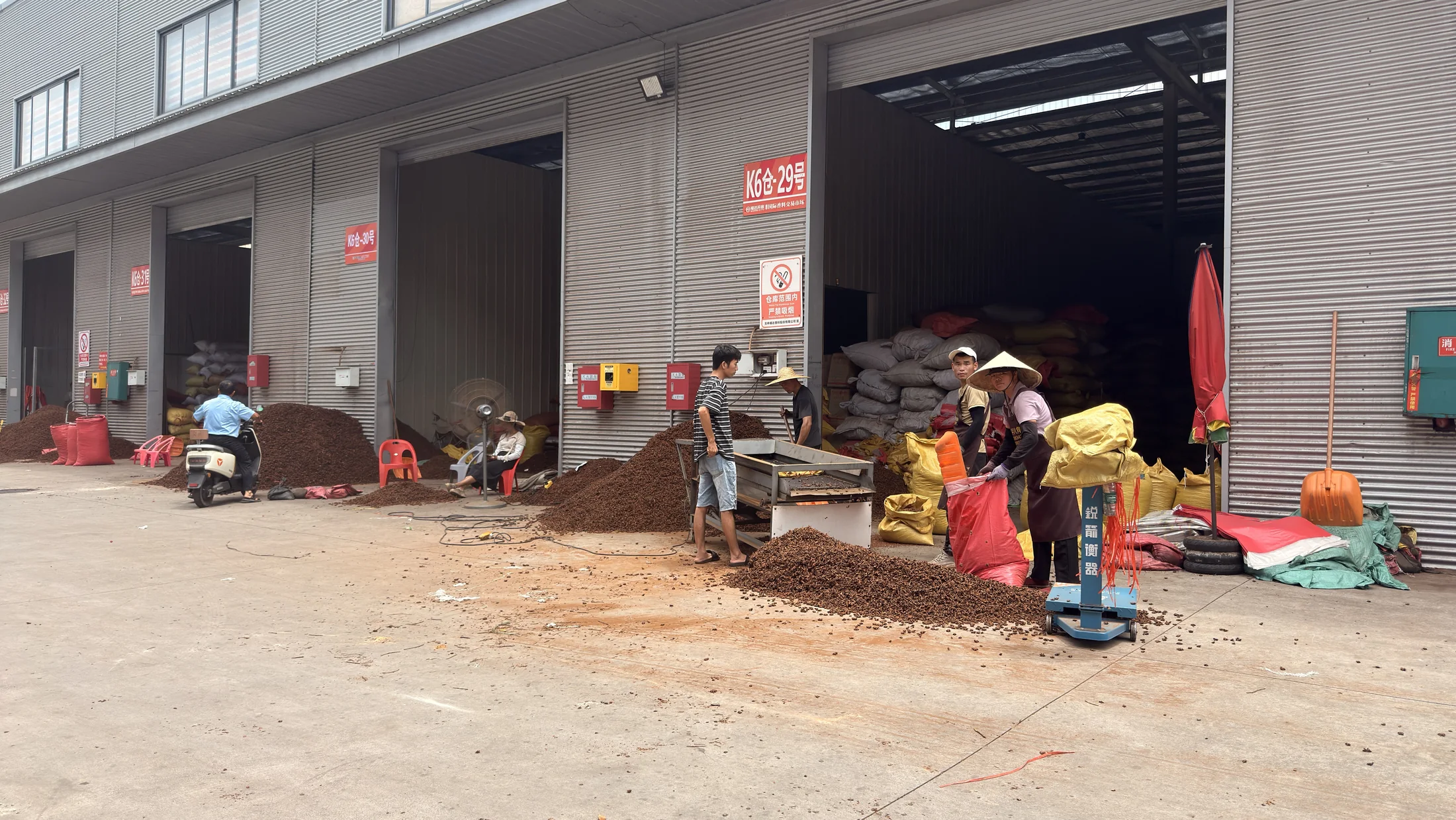 Workers handling spices outside warehouse units at Fuda Market