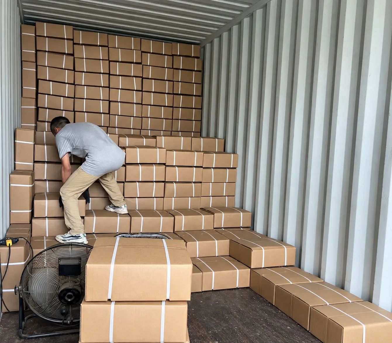 Worker loading cassia cartons into a shipping container